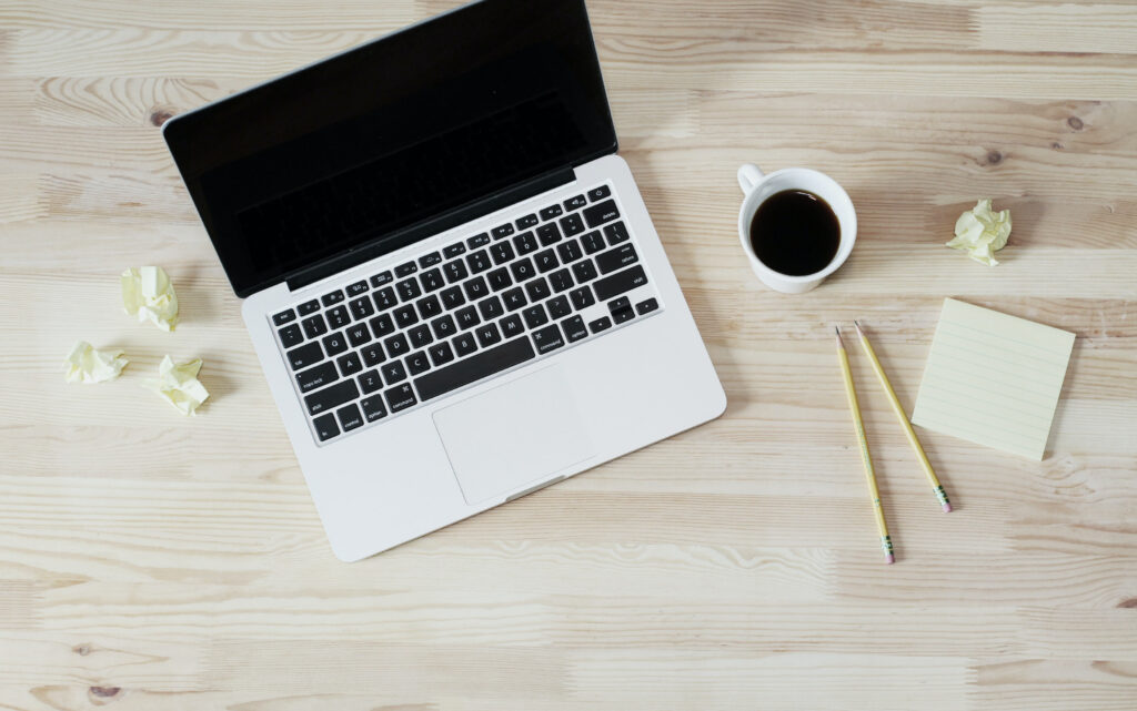 laptop and coffee cup with scrunched up post-its to show loneliness in entrepreneurship